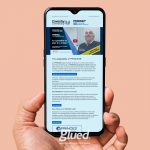 A hand holds a smartphone displaying a webpage about PRINCE2® at Coventry University, highlighting crisis planning and the adaptability of PRINCE2. A smiling individual in a suit is pictured, with glued marketing proudly shown on the phone case—showcasing a top branding agency in Warwickshire.
