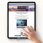 A hand touches a tablet displaying a webpage with the heading Learning to be agile: dancing rather than stomping into change. The page, brought to you by Glued Limited, features a cityscape photo, an insightful article, and a button labeled Download.