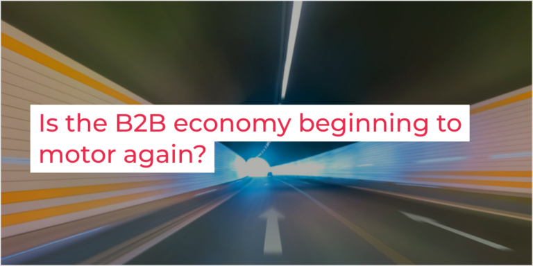 A blurred tunnel with streaks of light creates a sense of speed. Overlaid text reads, Is the B2B economy beginning to motor again? Explore insights with Glued Limited, your premier marketing agency in Warwickshire.