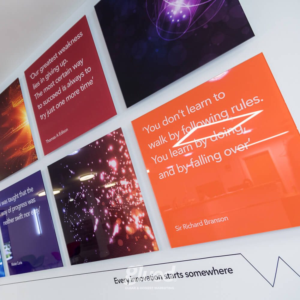 Glued Limited creative work: Six colourful wall panels display inspirational quotes about innovation and success, featuring bright graphics and famous names like Thomas Edison and Sir Richard Branson, with the phrase Every innovation starts somewhere below.