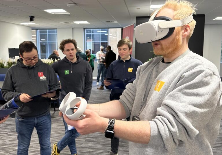 Teams Glued: A man wearing a VR headset and holding controllers engages with virtual content, demonstrating versatility as three colleagues observe and look at papers in a collaborative modern office setting.